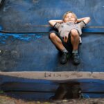 Feature image alt text: Happy boy relaxing on a slide with puddle reflection after rain. Image by mariya_m on Pixabay.